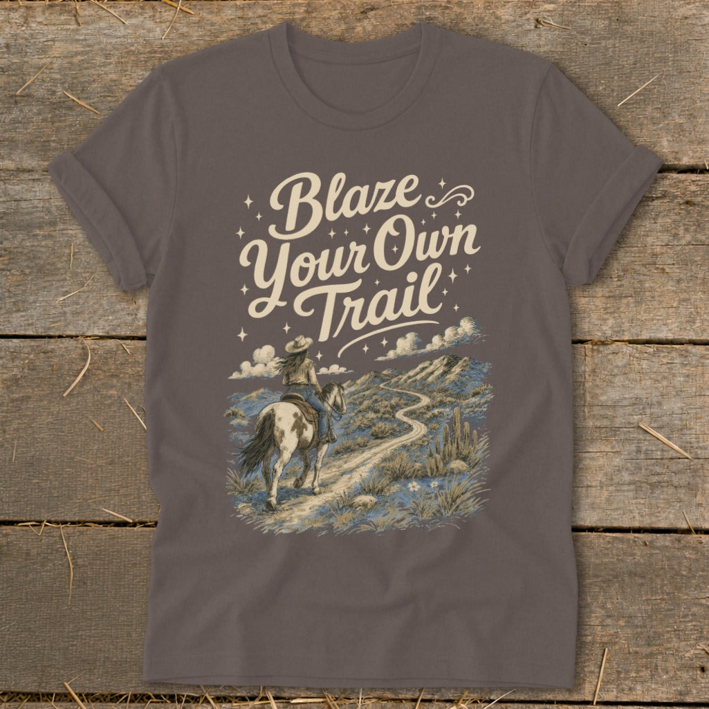 T-shirt with text "Blaze Your Own Trail" and a woman riding a horse on a desert path.