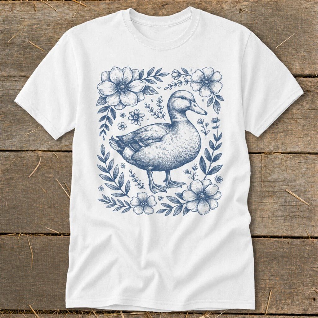 White t-shirt with a blue duck surrounded by flowers and leaves.