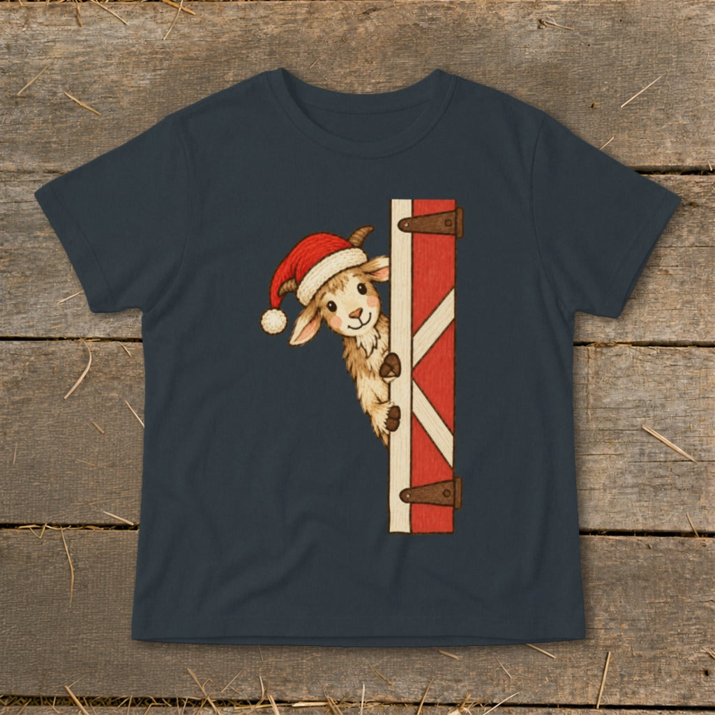 Goat wearing Santa hat peeking around a barn door graphic on a t-shirt.