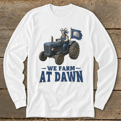 White long-sleeve shirt with graphic of goat on tractor, flag, and text "WE FARM AT DAWN".