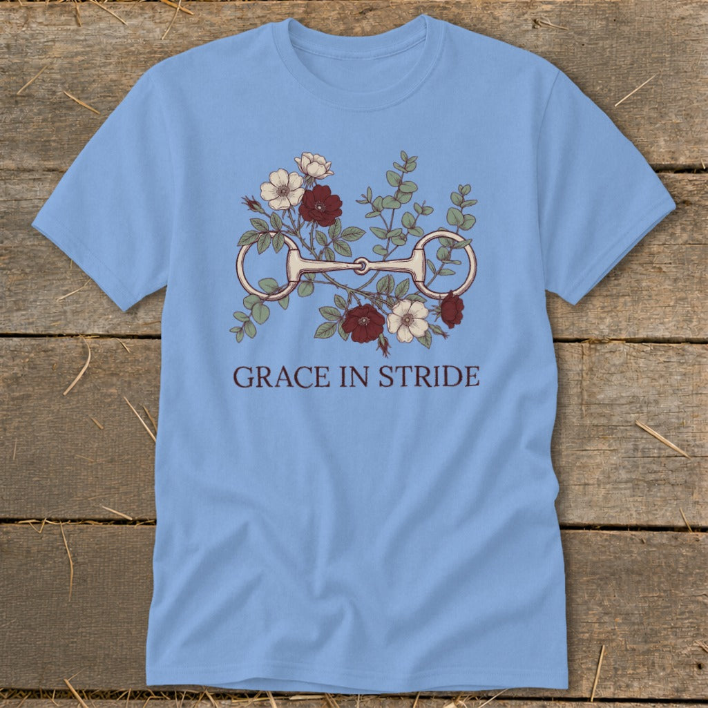 Light blue t-shirt with a horse bit and floral design, text "GRACE IN STRIDE".