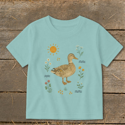 Light blue t-shirt with a duck and floral illustration under a sun.