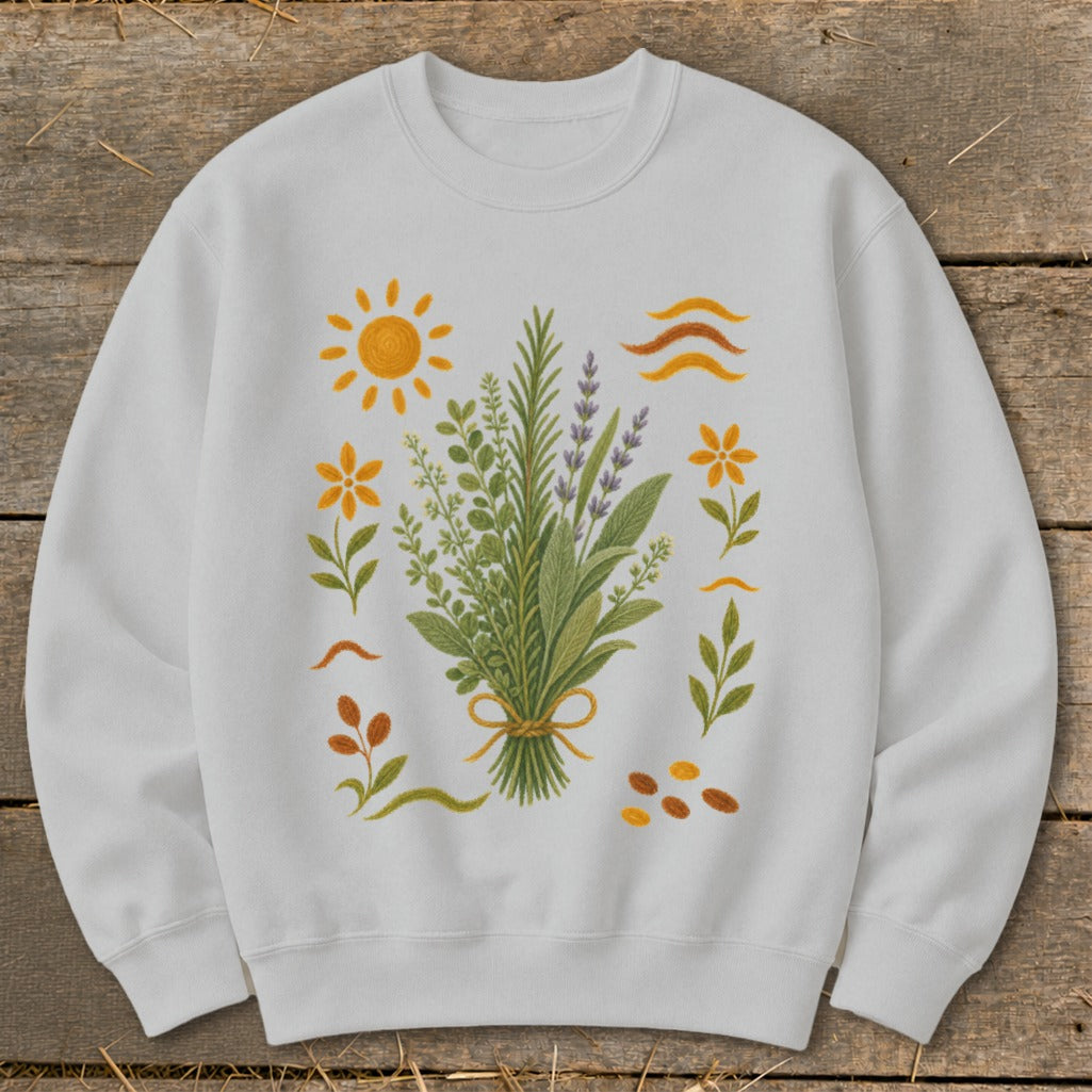 White sweatshirt with a botanical illustration of herbs, flowers, sun, and wavy lines.