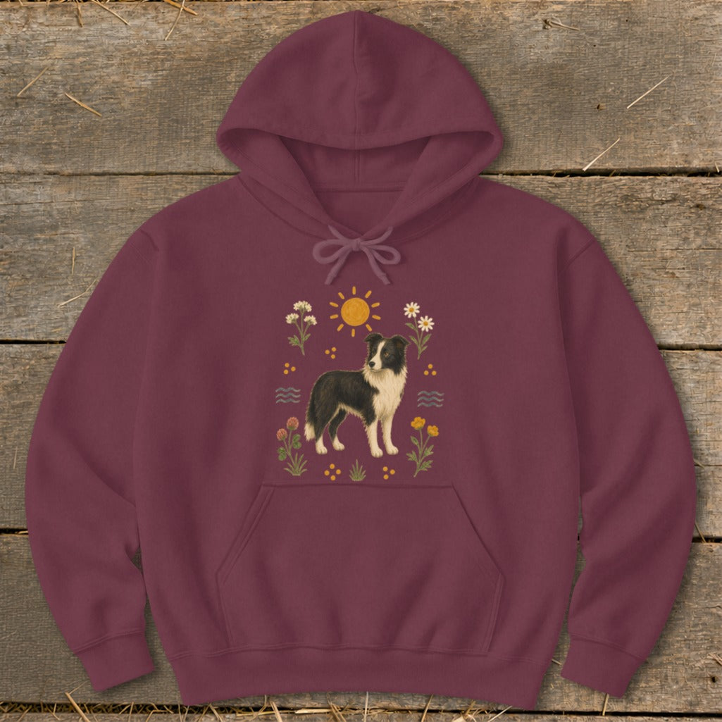 Maroon hoodie with a black and white Border Collie surrounded by flowers and sun graphic.