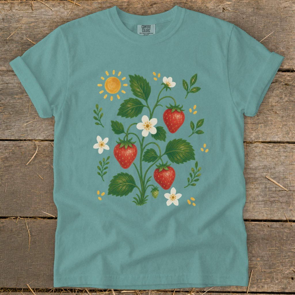 Teal t-shirt with a graphic of a strawberry plant with fruit, flowers, and a sun.