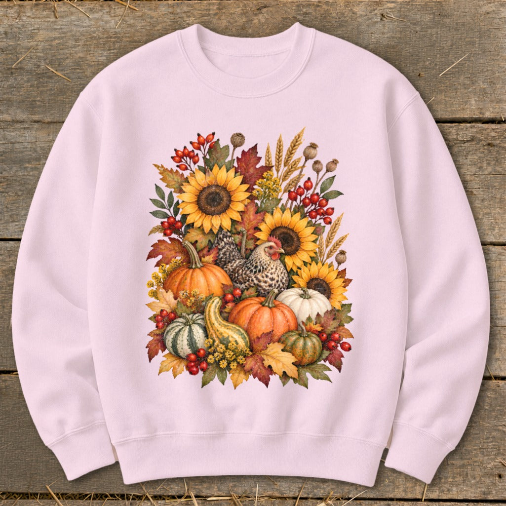Pink sweatshirt with a watercolor illustration of sunflowers, pumpkins, gourds, and a chicken.