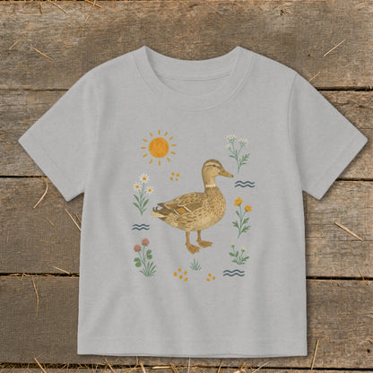 Light grey t-shirt featuring a brown duck surrounded by flowers, sun, and water.