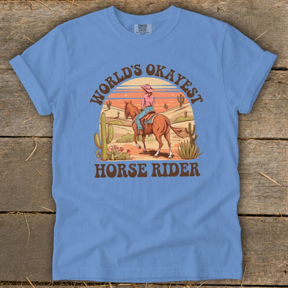 T-shirt with graphic: Woman riding horse in desert, text "World's Okayest Horse Rider".