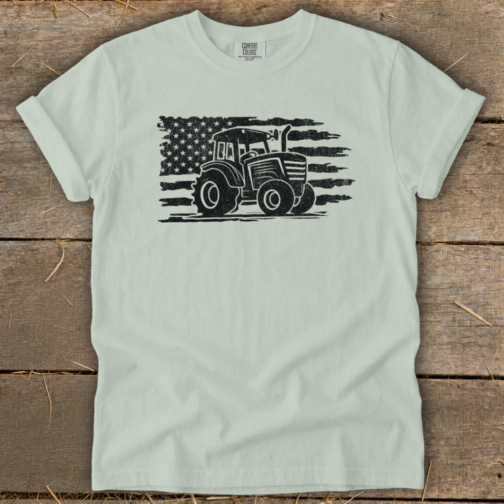 Light mint t-shirt with distressed black tractor superimposed on an American flag graphic.