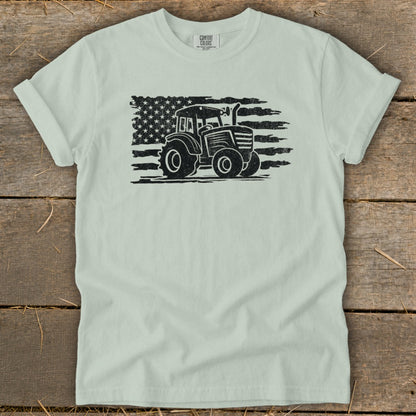 Light mint t-shirt with distressed black tractor superimposed on an American flag graphic.