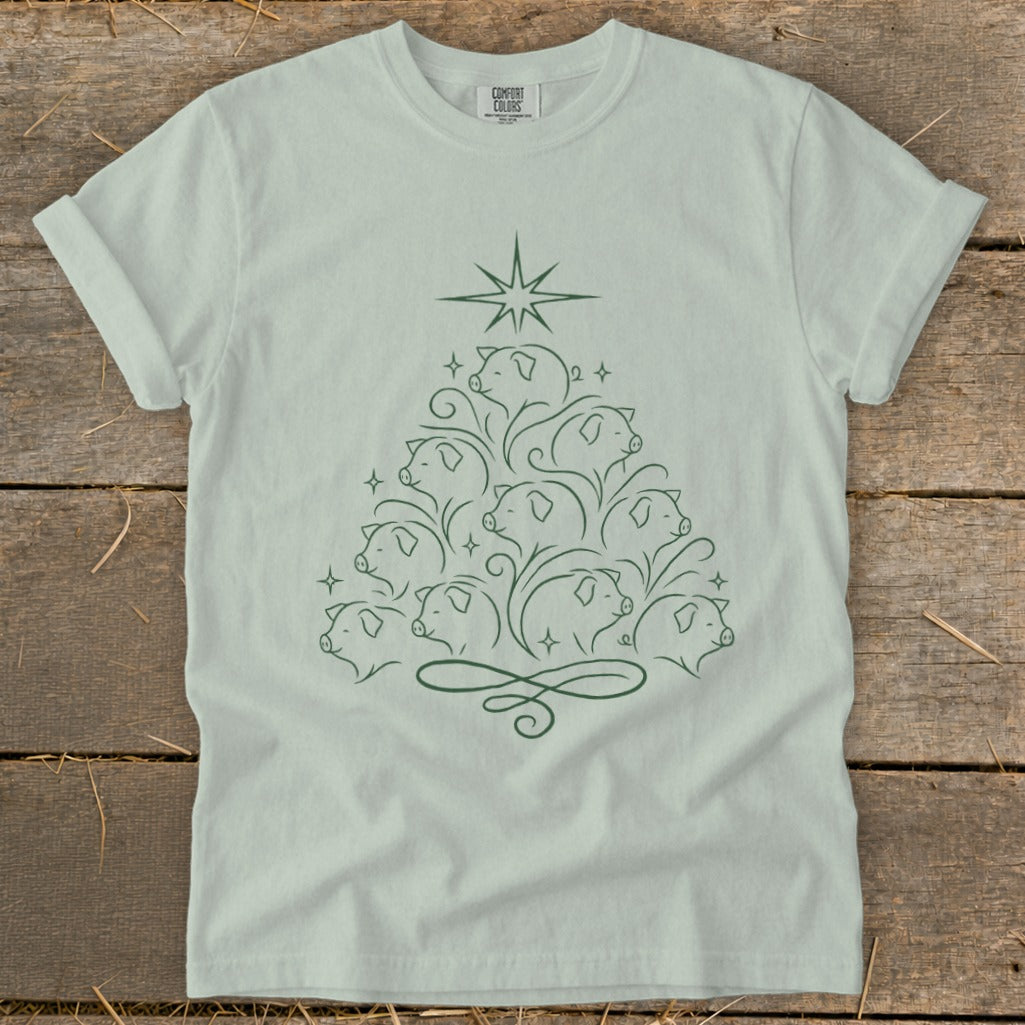 Light green t-shirt with a Christmas tree made of pig faces and swirls.