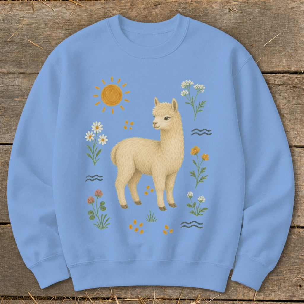 Light blue sweatshirt with a cream llama illustration surrounded by flowers and sun.
