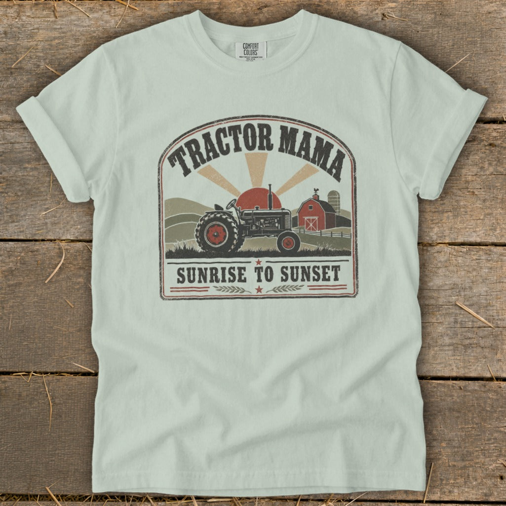 Light mint t-shirt with graphic of tractor, barn, and text "Tractor Mama Sunrise to Sunset".