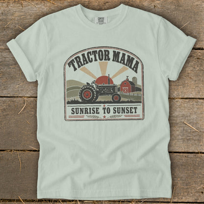 Light mint t-shirt with graphic of tractor, barn, and text "Tractor Mama Sunrise to Sunset".