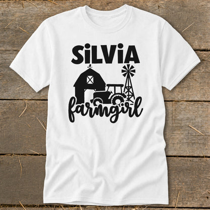 White t-shirt with "Silvia farmgirl" text and barn, tractor, and windmill graphic.
