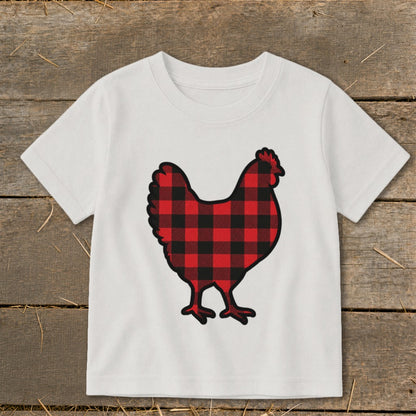 White t-shirt with a buffalo plaid chicken graphic on a wooden background.