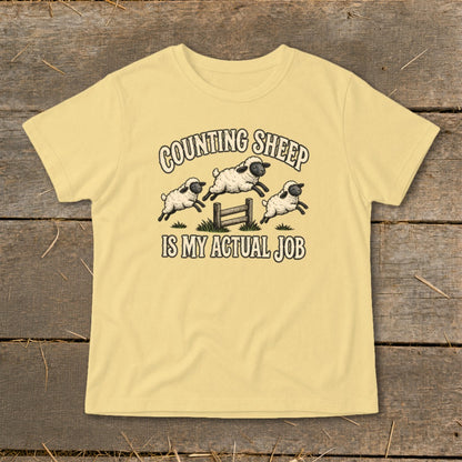 Yellow t-shirt with "Counting Sheep Is My Actual Job" and jumping sheep graphic.