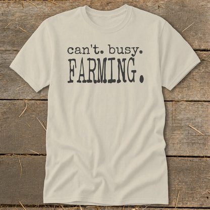 Cream t-shirt with "can't. busy. FARMING." text in dark gray.