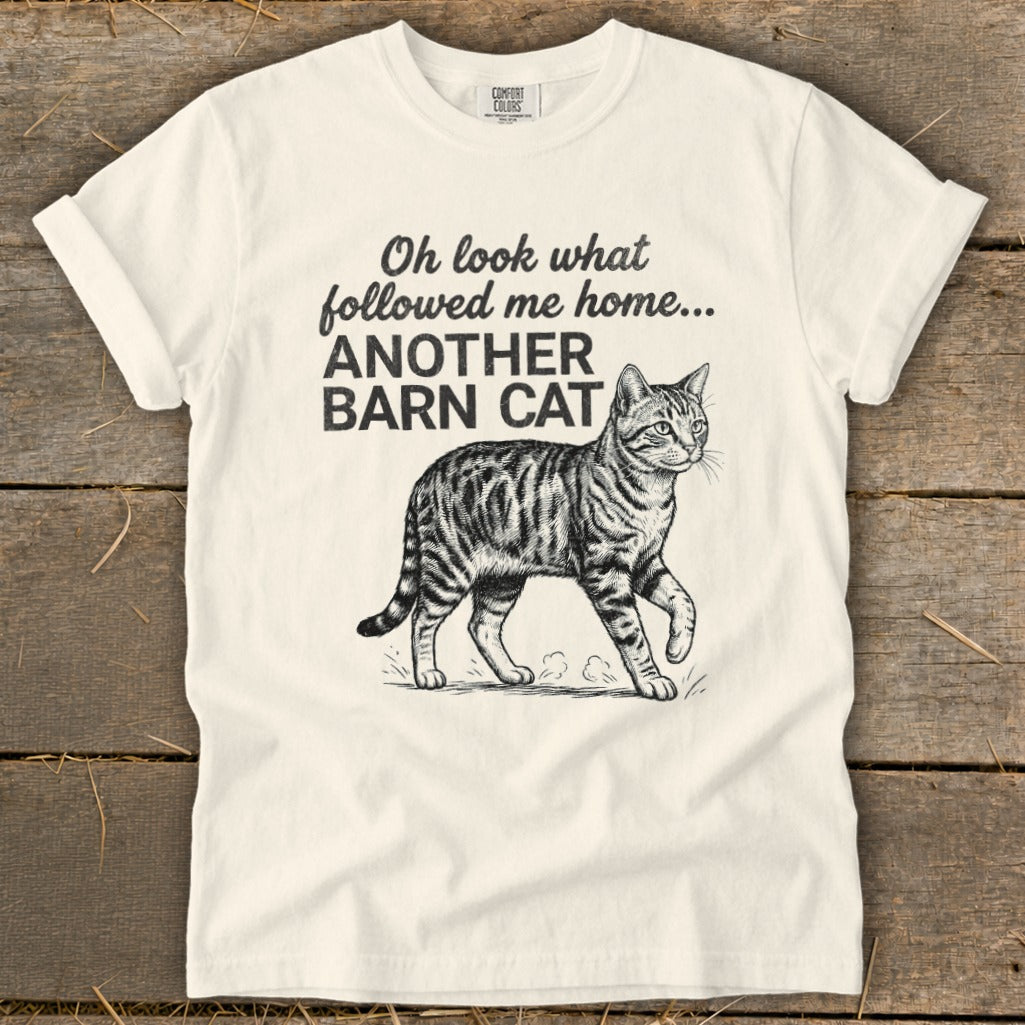 Cream t-shirt with text "Oh look what followed me home... ANOTHER BARN CAT" and a tabby cat illustration.
