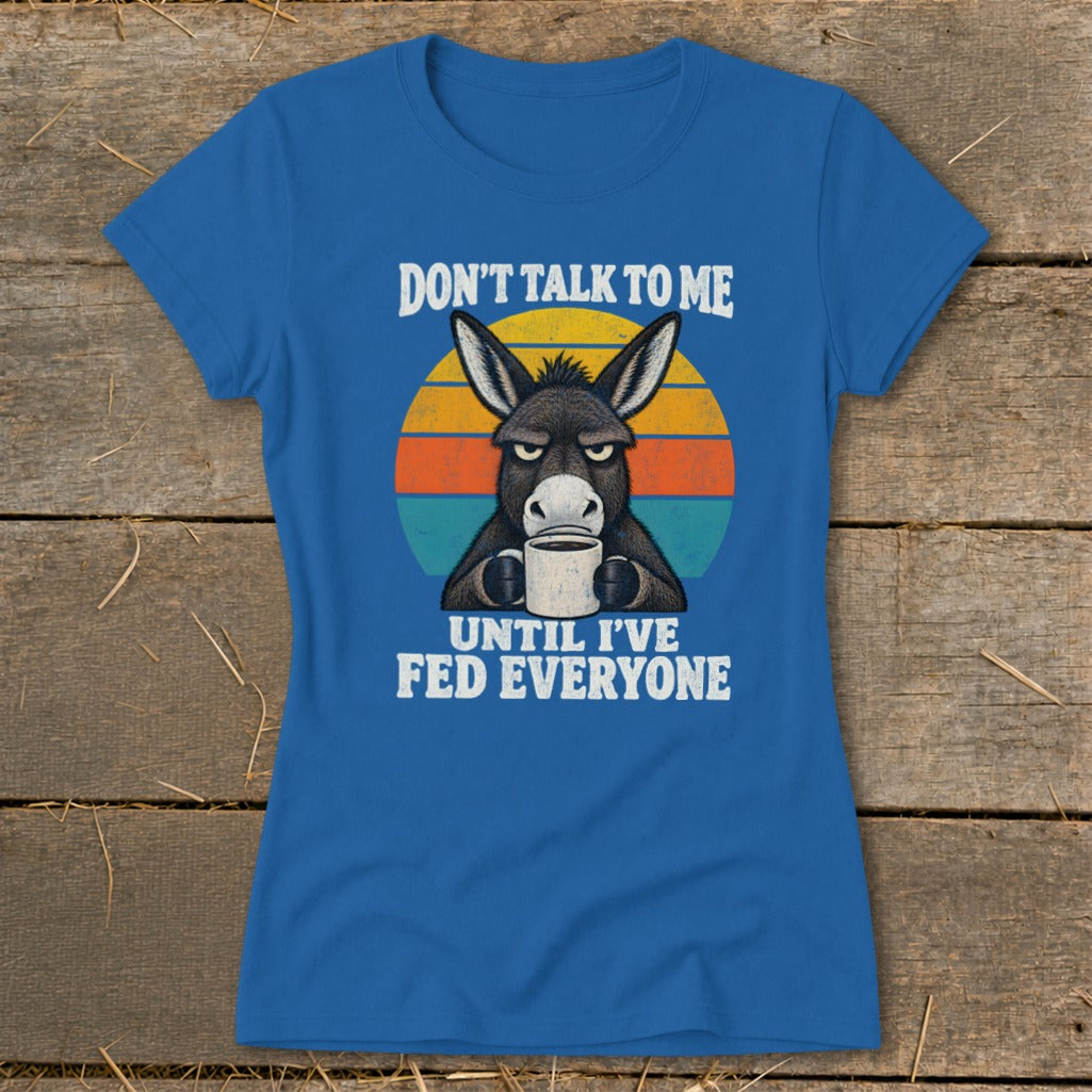 Blue t-shirt featuring an angry donkey holding a coffee mug, set against a retro sunset graphic with text.