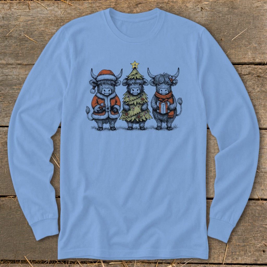 Three Highland cows in festive Christmas attire, one dressed as Santa, one as a tree, one with a gift.