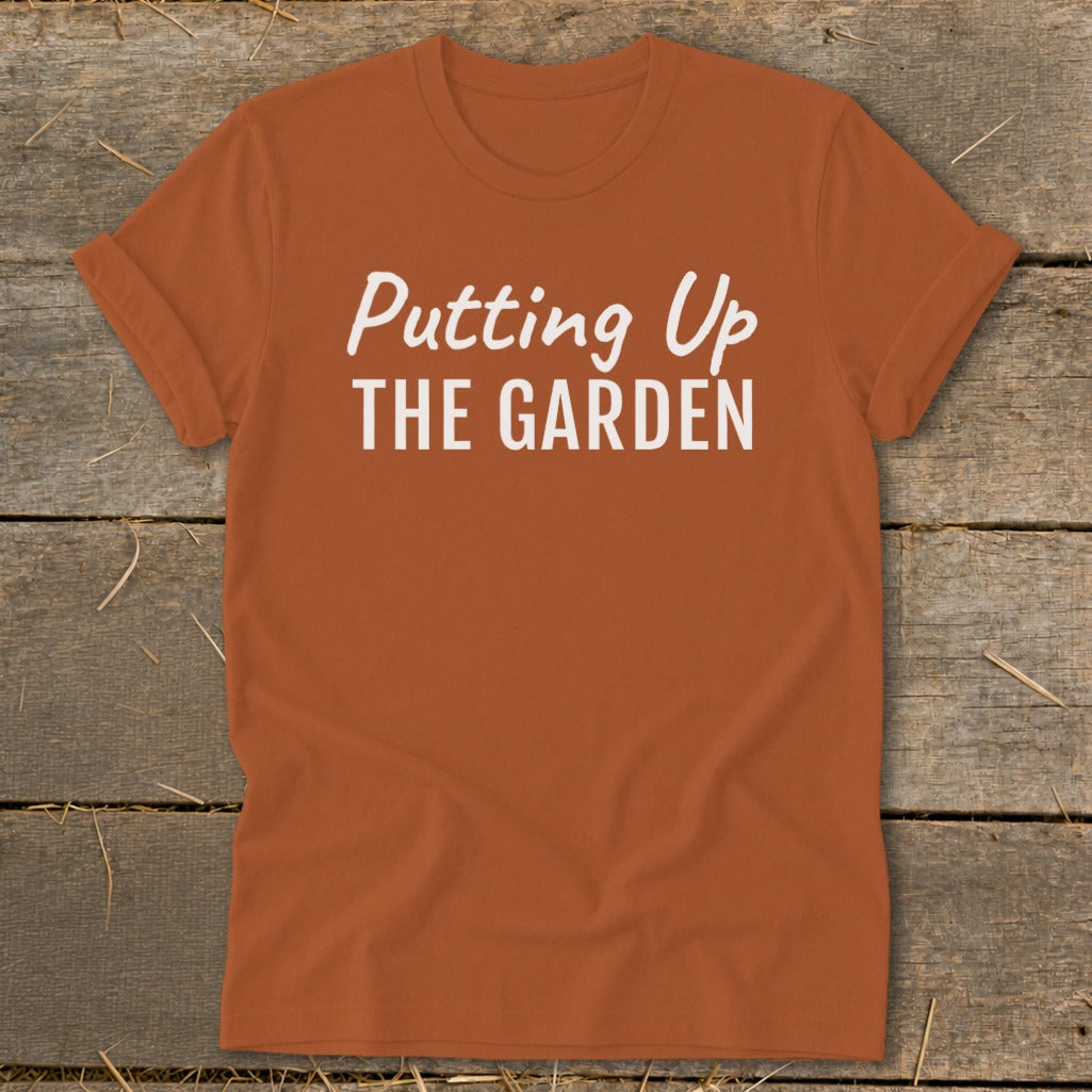 Orange t-shirt with white text reading "Putting Up THE GARDEN".