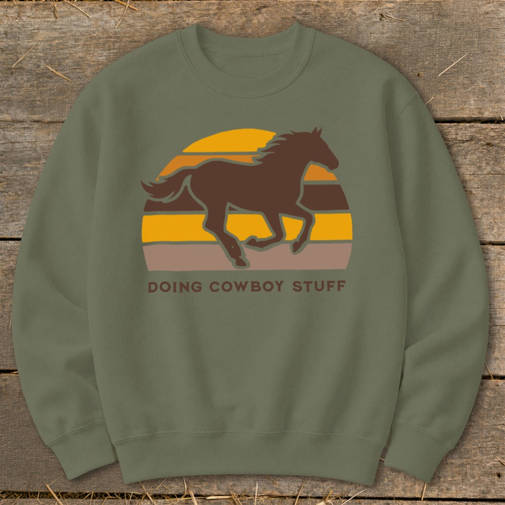Brown horse silhouette in front of a striped sunset with text "DOING COWBOY STUFF".