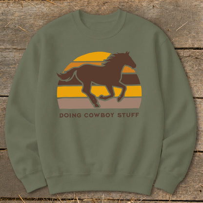 Brown horse silhouette in front of a striped sunset with text "DOING COWBOY STUFF".