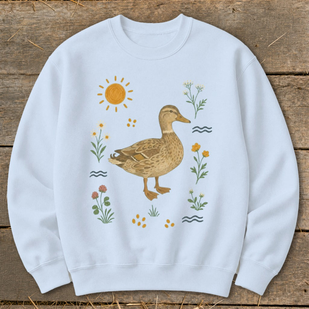 Light blue sweatshirt with a watercolor duck and floral illustration.