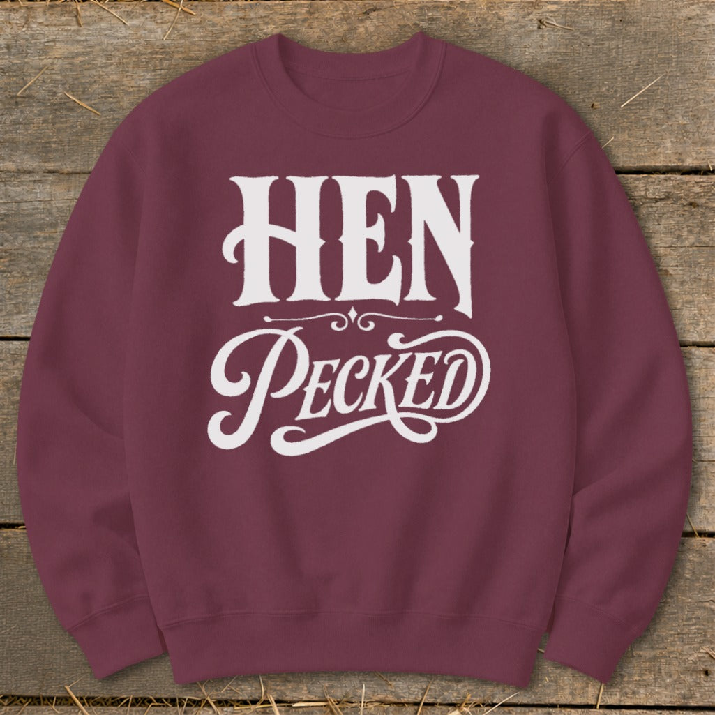 Maroon sweatshirt with white text reading "HEN Pecked" in decorative font.