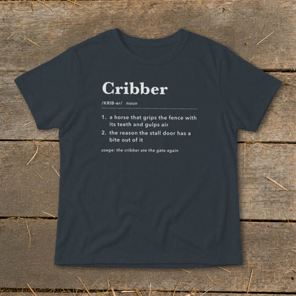 Dark gray t-shirt featuring a humorous dictionary definition of the word Cribber printed in white.