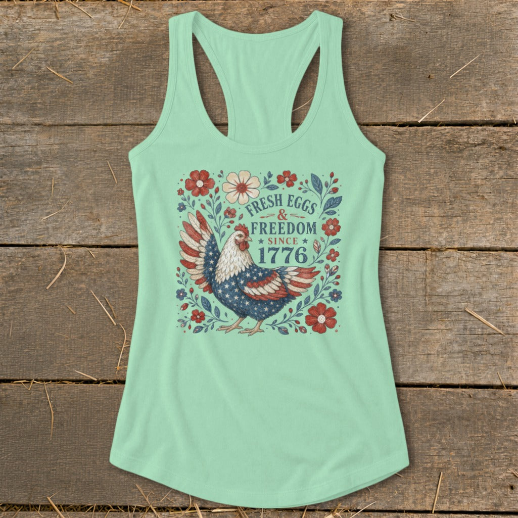 Mint green tank top with a chicken graphic and text "Fresh Eggs & Freedom Since 1776".
