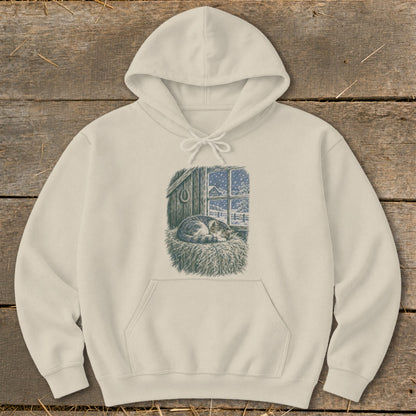 Cream hoodie with graphic of a sleeping cat on hay by a snowy window.
