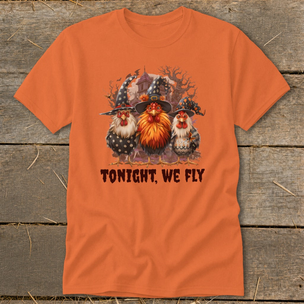 Three chickens in witch hats on an orange t-shirt with text "TONIGHT, WE FLY".