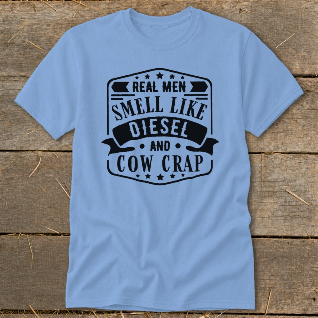 Light blue t-shirt with black text graphic that reads "Real Men Smell Like Diesel and Cow Crap".