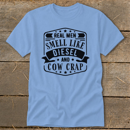Light blue t-shirt with black text graphic that reads "Real Men Smell Like Diesel and Cow Crap".