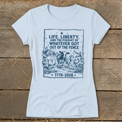 Light blue t-shirt with blue graphic of farm animals and text: "Life, Liberty, and the Pursuit of Whatever Got Out of the Fence 1776-2026."