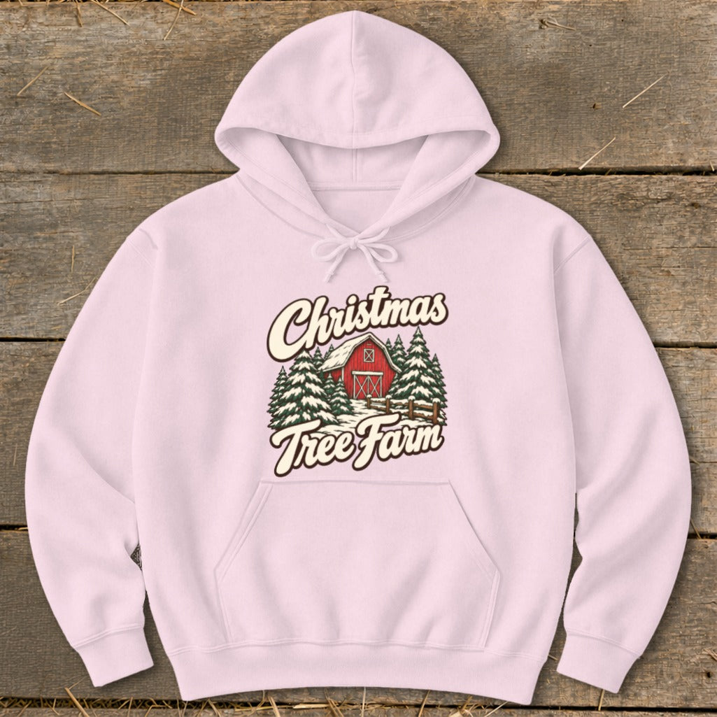 Pink hoodie with Christmas Tree Farm graphic featuring a red barn and pine trees.