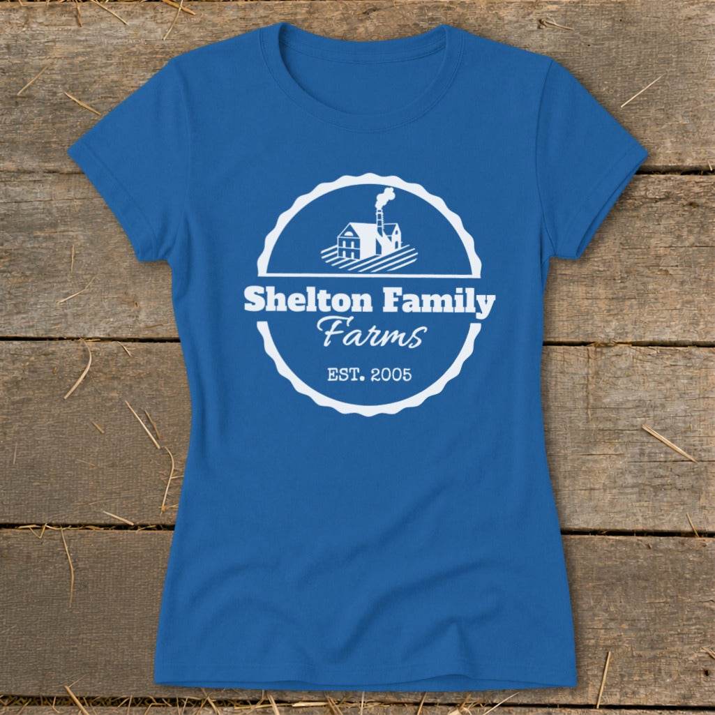 Blue t-shirt with white "Shelton Family Farms EST. 2005" logo and farm house graphic.