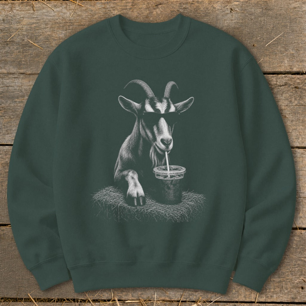 Goat wearing sunglasses drinks from a cup with a straw, depicted on a dark green sweatshirt.
