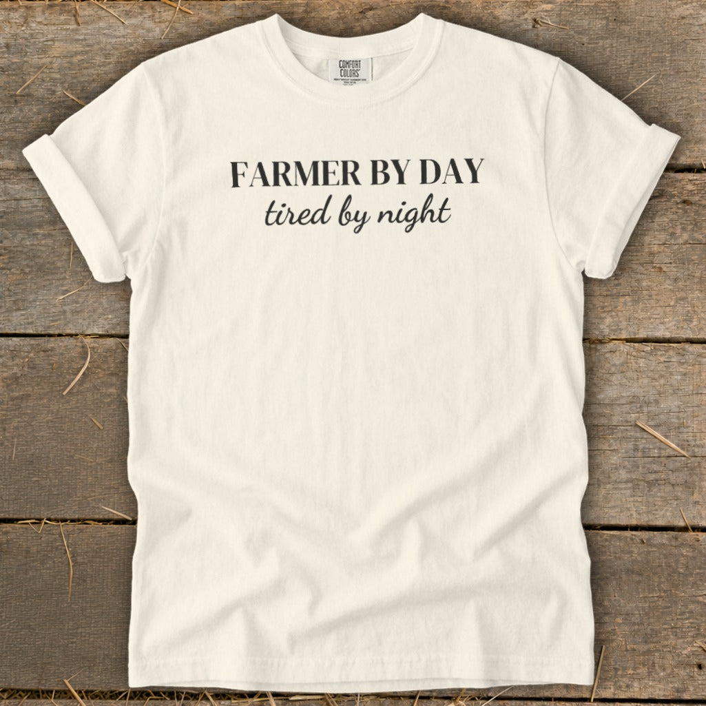 Cream t-shirt with "FARMER BY DAY tired by night" text in black.