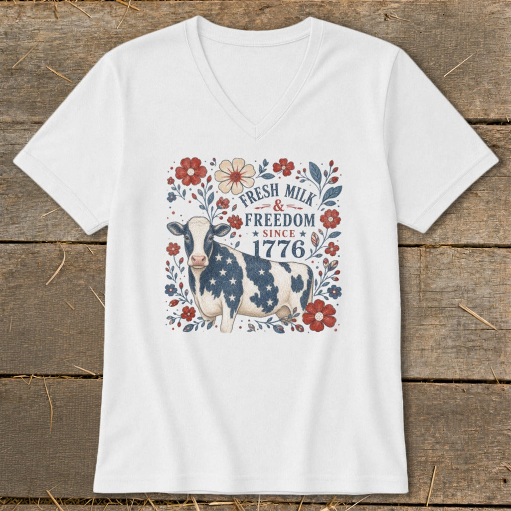 White v-neck t-shirt with cow, flowers, and text: "FRESH MILK & FREEDOM SINCE 1776".