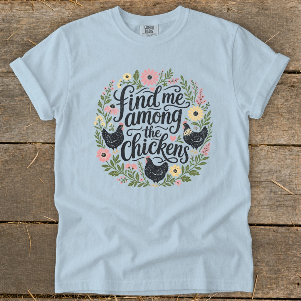 Light blue t-shirt with floral wreath and chickens graphic that reads "Find me among the chickens."