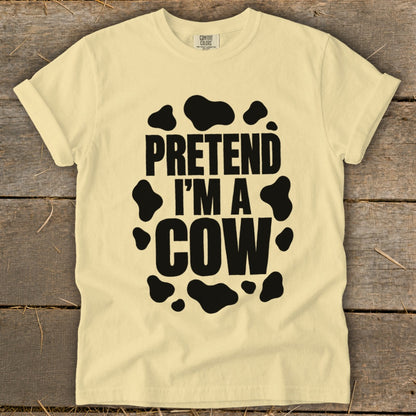 Yellow t-shirt with black text "PRETEND I'M A COW" and cow spots.