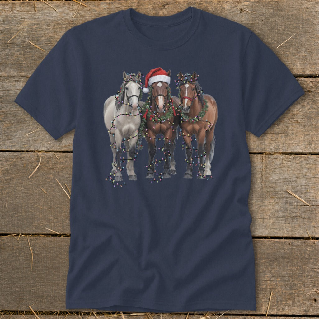 Three horses wearing Christmas lights and garlands, one with Santa hat.