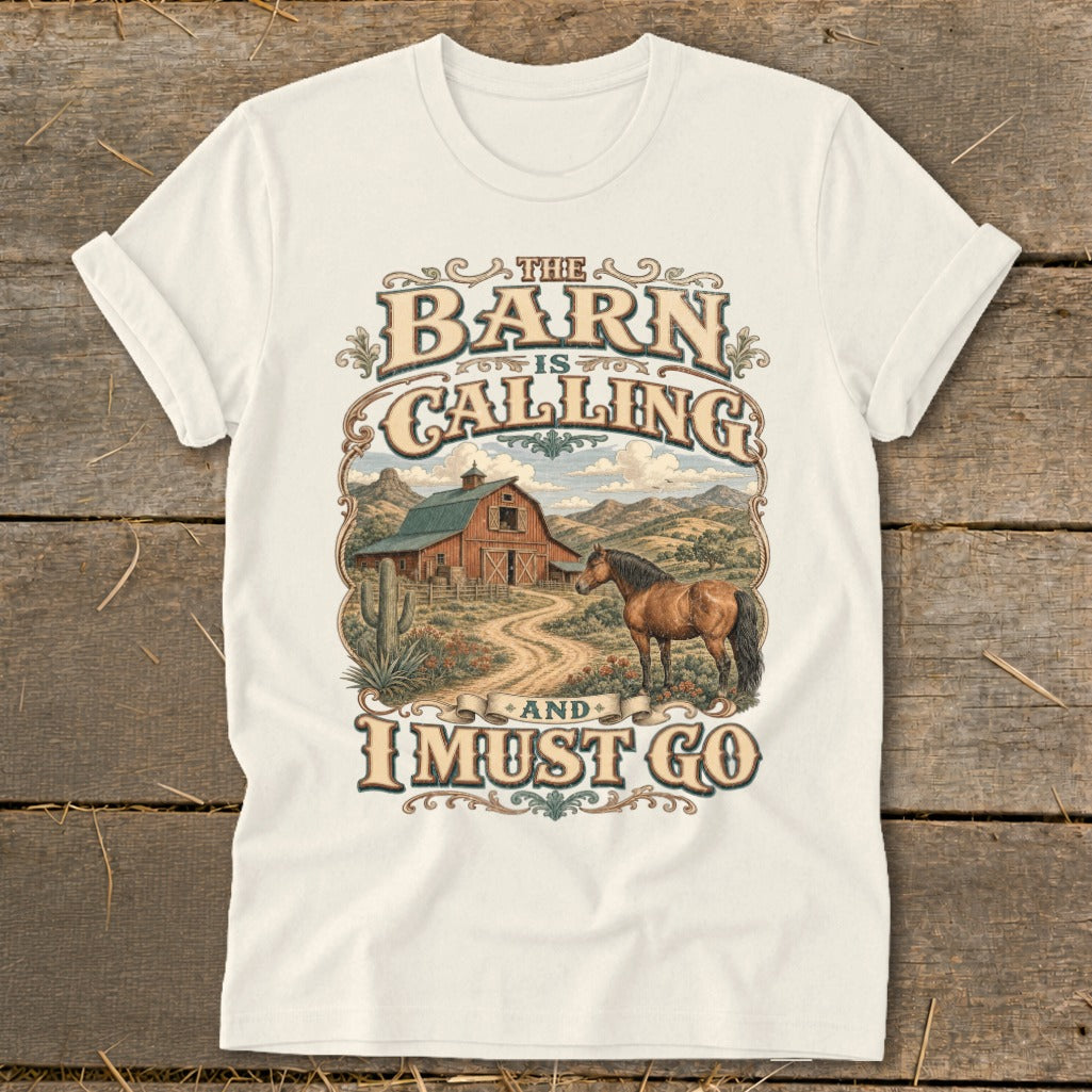 "The Barn is Calling and I Must Go" graphic on a cream t-shirt with a horse and barn scene.
