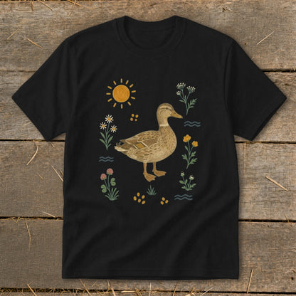 Black t-shirt with a watercolor duck surrounded by flowers and the sun.