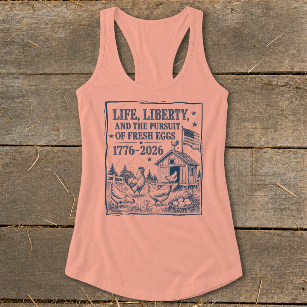 Peach tank top with "Life, Liberty, and the Pursuit of Fresh Eggs 1776-2026" text and farm scene.