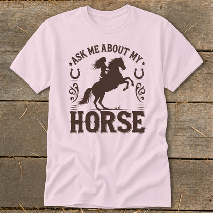 Pink t-shirt with dark brown text and silhouette of a rider on a rearing horse.