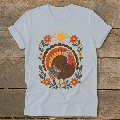Light blue t-shirt with a Thanksgiving turkey design featuring a sun and floral wreath.